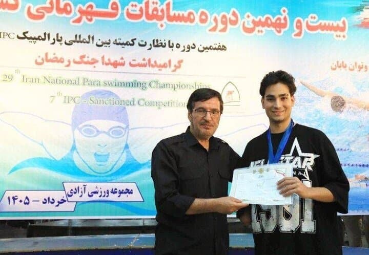 اهداي نشان مسابقات پاراشنا به شناگر جانباز جنگ رمضان