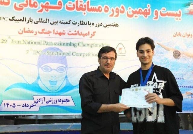 اهداي نشان مسابقات پاراشنا به شناگر جانباز جنگ رمضان